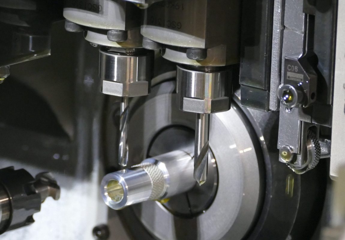 Red anodised aluminium turned components with threaded ends and slotted openings